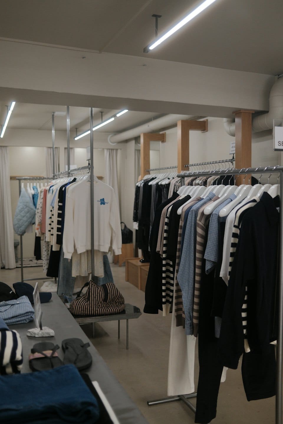 Kleiderständer mit Kleidung und Accessoires in einer modernen Boutique.